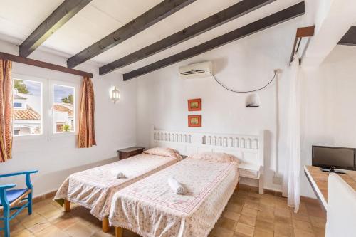 a bedroom with two beds and a flat screen tv at Cala Serena Beach in Felanitx