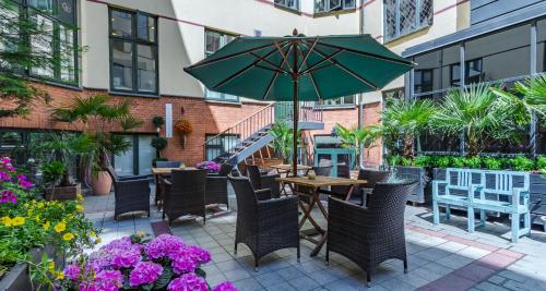 a patio with a table and chairs and an umbrella at Best Western Hotel Hebron in Copenhagen