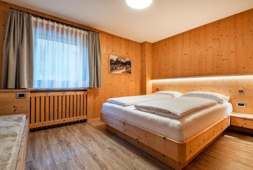 a bedroom with a large bed and a window at Stoffel Apartments Martina in Selva
