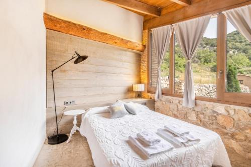 a bedroom with a bed in a room with windows at El Cobert De Lera in Oden