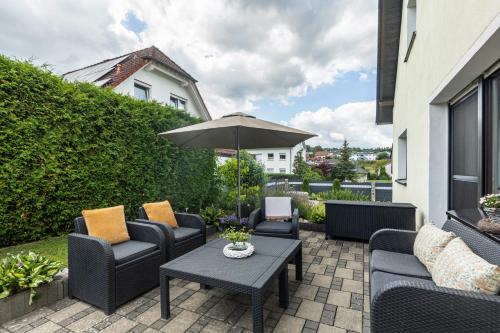 a patio with chairs and a table with an umbrella at Ferienwohnung Sonnenblick und Relax in Nieder-Röhre