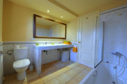 a bathroom with a toilet and a sink and a mirror at Royal Horizón Dúplex in Navata