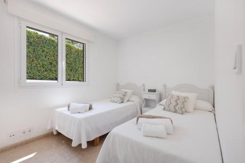 two beds in a white room with two windows at V206 Villa Isabel in Son Bou