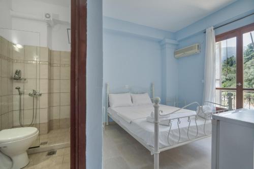 a bedroom with a bed and a shower and a toilet at Giorgio studios-apartments 1 in Nikiana