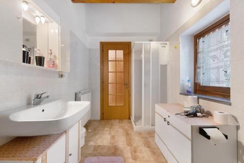 a white bathroom with a sink and a mirror at Casa Vendrogno in Bellano