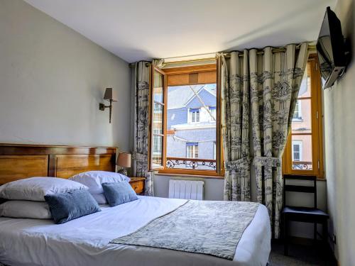 a bedroom with a large bed and a window at Entre Terre Et Mer in Honfleur