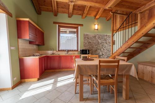 a kitchen with red cabinets and a table with chairs at Civico 2 in Marmora