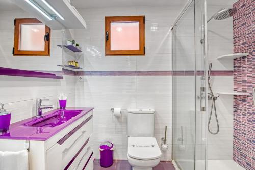 ein Badezimmer mit einem lila Waschbecken und einer Toilette in der Unterkunft Violeta in Macastre