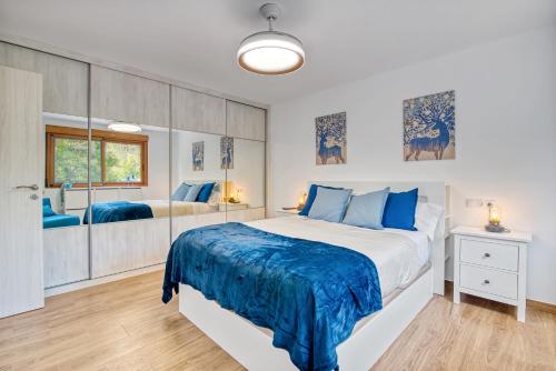ein Schlafzimmer mit einem großen Bett und blauen Kissen in der Unterkunft Violeta in Macastre