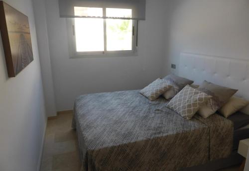 a bedroom with a bed with a window at Great apartment with pool - jacuzi in Villacosta
