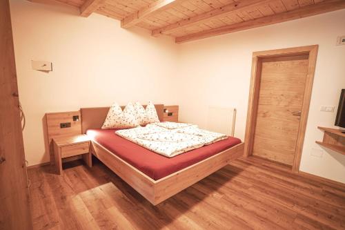 a bedroom with a bed and a wooden floor at Apartment Toni - Obermösslhof in Lana