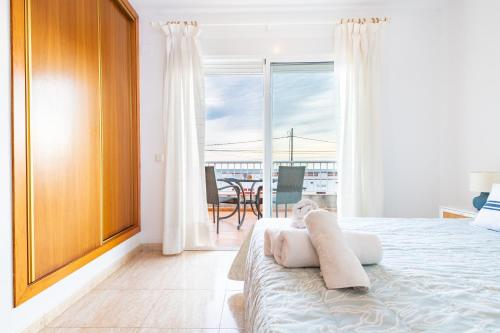a bedroom with a bed and a balcony with a table at Casa Mar in Vinarós