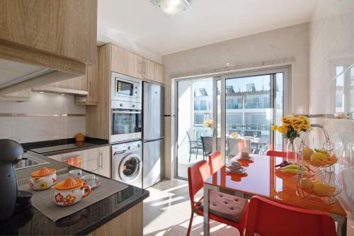 a kitchen with a table with red chairs and a dining room at Numar Residence Villa X in Manta Rota