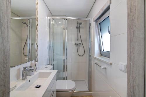 a bathroom with a shower and a sink and a toilet at Numar Residence Villa X in Manta Rota