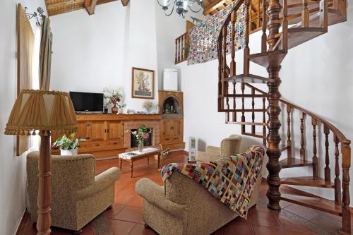 a living room with chairs and a spiral staircase at Casa das Rosas in Angra do Heroísmo