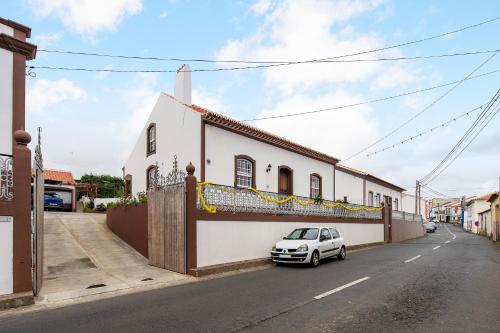a white car parked in front of a building at Casa das Rosas in Angra do Heroísmo