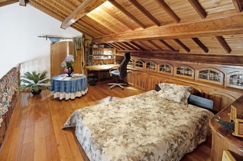 a bedroom with a large bed and a desk at Casa das Rosas in Angra do Heroísmo