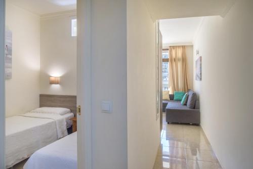 a bedroom with two beds and a living room with a couch at Marina view sunny apartment in Fuengirola