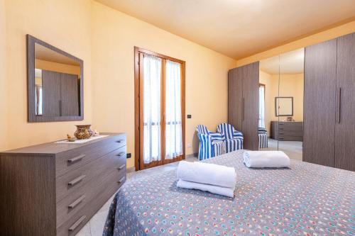 a bedroom with a bed with a dresser and a mirror at Casa Caterina con giardino in Marone
