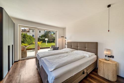a bedroom with a large bed and a large window at vinum - schlosserhaus 31 in Tesimo