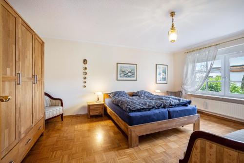 a bedroom with a blue bed and a window at Ferienhaus Erlengrund A in Schafstedt