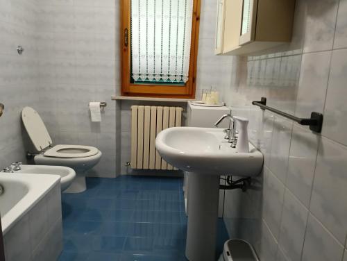 a white bathroom with a sink and a toilet at Il SORRISO in Moie
