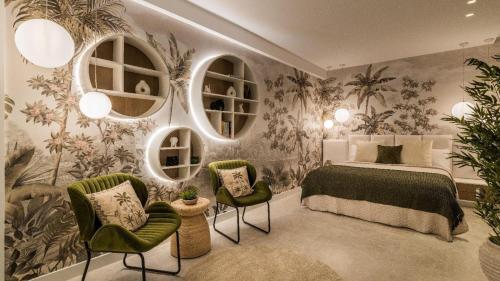 a bedroom with a bed and two chairs and mirrors at Villa 11 Sunset in Marbella