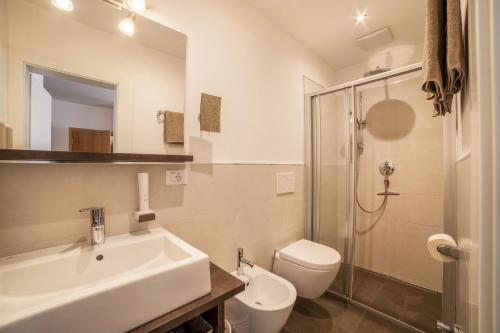 a bathroom with a sink and a toilet and a shower at Schnitzer Ferienwohnung Holunder in Rablà