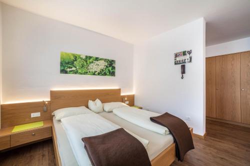 a bedroom with a large bed and a cross on the wall at Schnitzer Ferienwohnung Holunder in Rablà