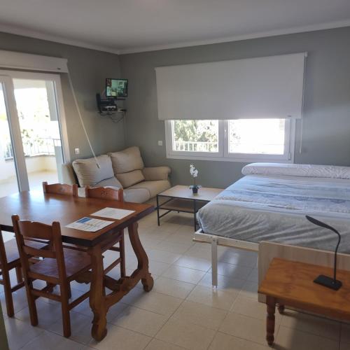 a bedroom with a bed and a table and a couch at Apartamento Portosun Pez in Portocolom