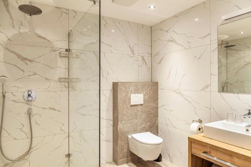 a bathroom with a shower and a toilet and a sink at Ferienwohnung Wetterstein in Ehrwald