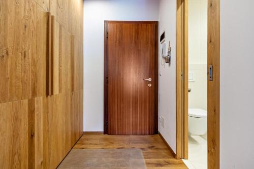 a bathroom with a wooden door and a toilet at Chalet Hubertus in Kastelruth