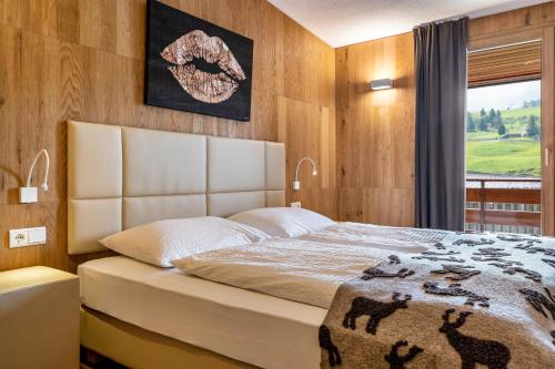 a bedroom with a large bed with wooden walls at Chalet Hubertus in Kastelruth