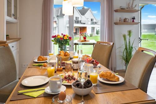 a dining room table with breakfast food and orange juice at Fewo Meerwert by Seeblick Ferien in Kappeln
