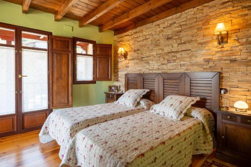 two beds in a bedroom with green walls and wooden floors at Paz y Tranquilidad in Melarde