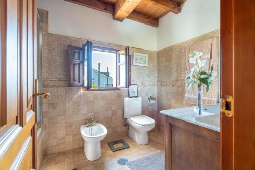 a bathroom with a toilet and a sink and a window at Paz y Tranquilidad in Melarde