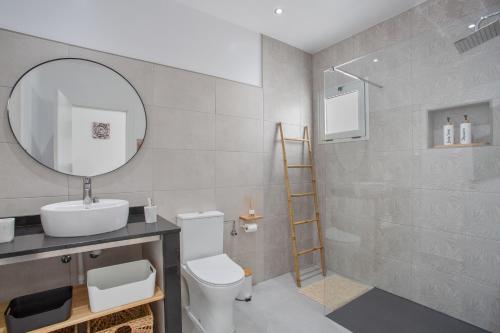 a bathroom with a toilet and a sink and a mirror at Casa Gara Fuerteventura in Gran Tarajal