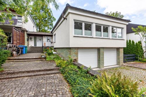 a white house with a brick driveway at Ferienwohnung Elim in Olsberg