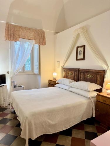 a bedroom with a large white bed and a window at Masseria Rienzo in Ostuni