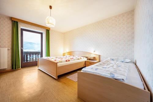 a bedroom with two beds and a window at Ferienwohnung Gatscherhof in Luson