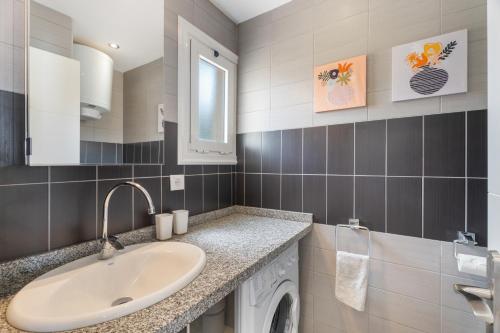 a bathroom with a sink and a washing machine at La Perla in Callao Salvaje