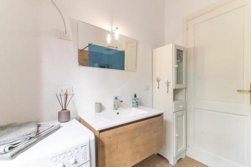 a white bathroom with a sink and a mirror at Villa Rosa sul mare in Olbia