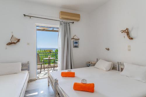 a bedroom with a white bed and a balcony at Perasma Studio 4 in Kipri