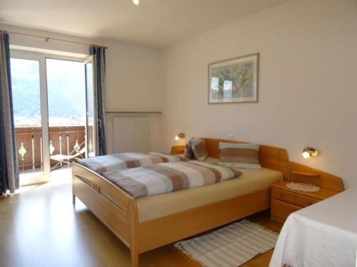 a bedroom with a large bed and a large window at Ferienwohnungen Oberbrunnhof in Naturno