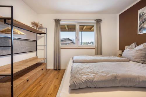 a bedroom with two beds and a window at Ferienwohnung Alpenvorland in Seeg