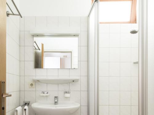 a white bathroom with a sink and a mirror at Fewo Schneckenhalde App 12 in Bad Säckingen