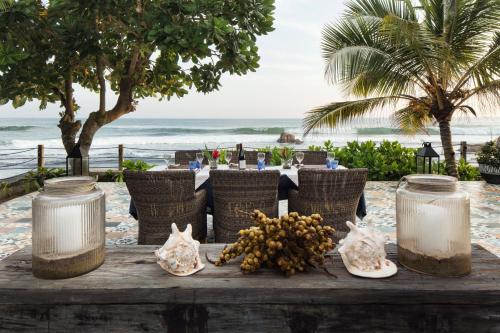 a table on the beach with a bunch of fruit on it at Owl and the Pussycat Hotel & Restaurant in Unawatuna