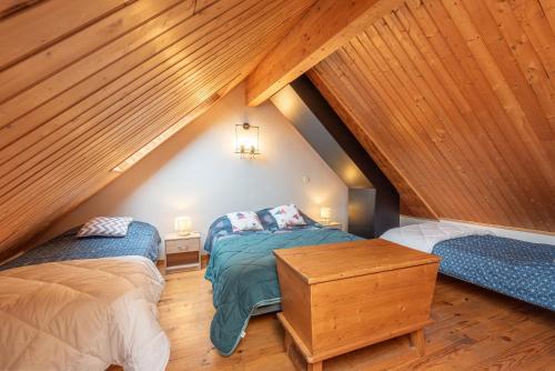 two beds in a attic room with wooden ceilings at Gîte Centre Luz-Saint-Sauveur in Luz-Saint-Sauveur