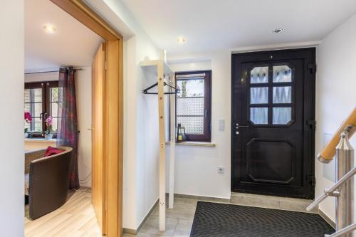 a hallway with a black door and a window at Ferienhaus Am Reiterhof in Templin