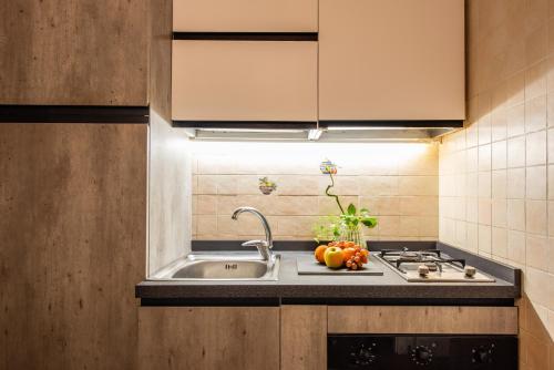 a kitchen with a sink and a stove and a sink at Romantica Corte Degli Estensi in Ferrara